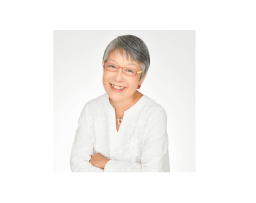 An image of Kumiko Ninomiya, PhD; a smiling woman in a white shirt and glasses