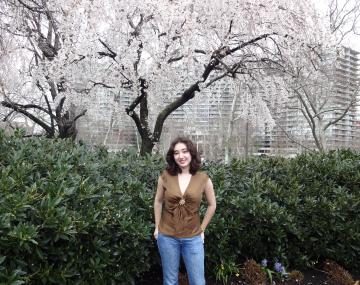 Girl standing in front of a big tree