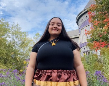 Gahsëni'de' smiles for the camera in front of Akwe:kon.