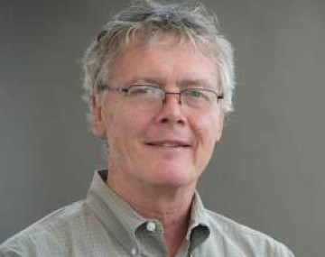 Photograph of a man with silver hair and glasses.