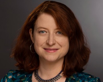 Photograph of a woman with dark hair wearing a necklace.