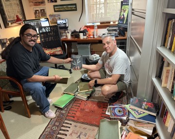 Zelazzie smiles and holds a book.