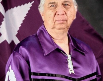 Kenneth Atsenhaienton Deer stands in a ribbon shirt.