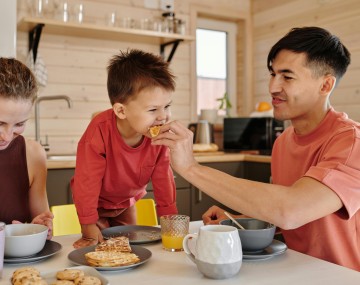 two adults and a child eating 