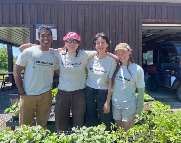 four students in t-shirts with the Dilmun Hill logo