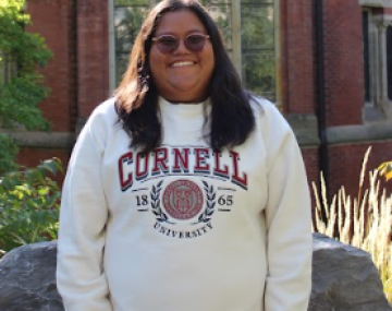 A photo of Arely in front of Sage Chapel