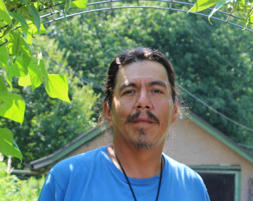 Stephen stands in a garden.