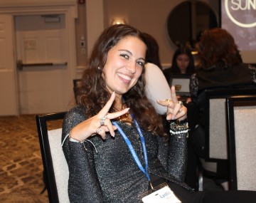 Girl in a chair making a peace sign with her fingers