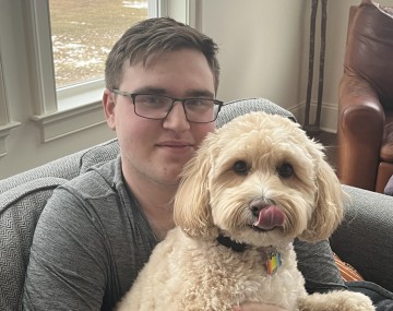 Person sitting with a dog on his lap